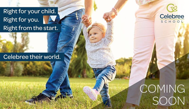 A father and mother holding hands with their little girl as they walk through a field.